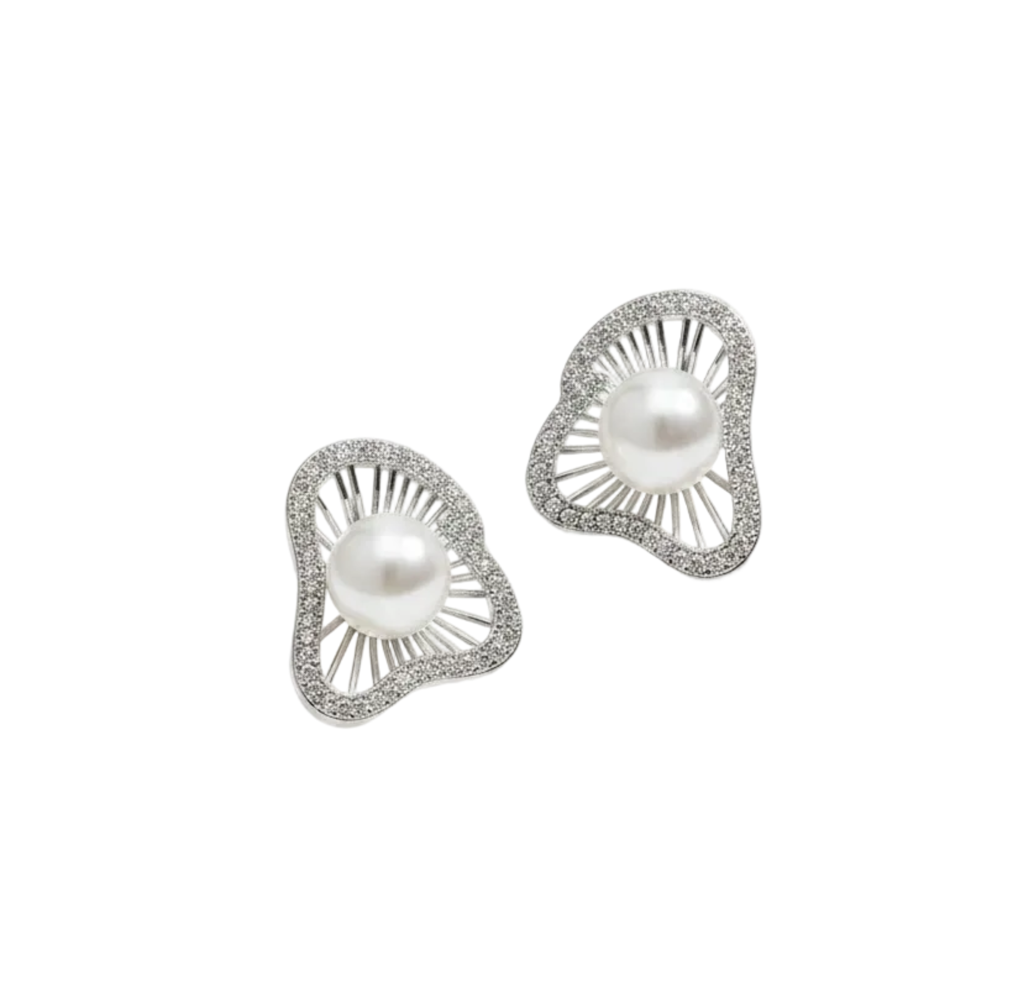 A pair of silver-toned statement earrings with oval white pearls and pavé-set clear stones, displayed on a cream-colored jewelry box over draped satin fabric.