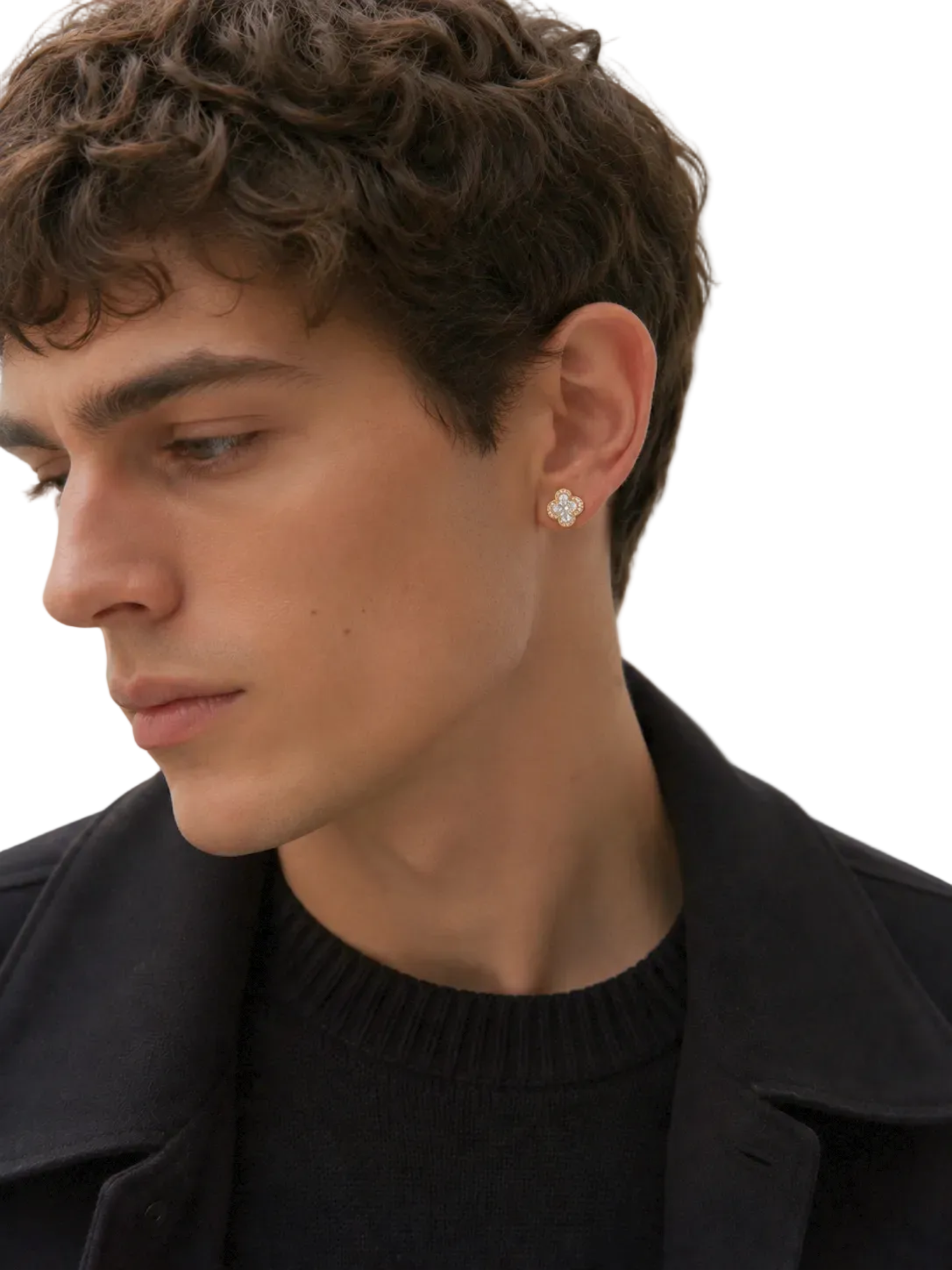 A close-up of a man wearing a small, clear, geometric stud earring on his earlobe, dressed in a black sweater and jacket against a neutral light gray background.