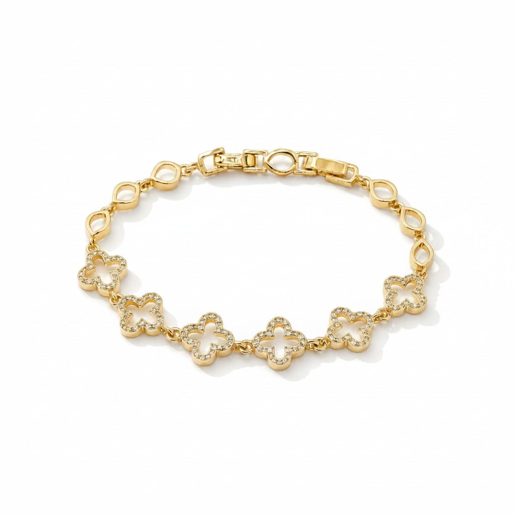 A gold bracelet featuring five openwork four-leaf clover motifs paved with small clear stones, displayed on a clean off-white background.