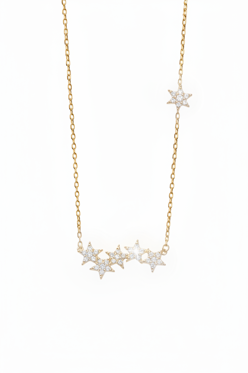 A delicate gold chain necklace featuring a horizontal bar with four small snowflake-like clusters, each set with clear stones, and a smaller matching snowflake cluster on the upper right side of the chain, photographed on a clean white background.