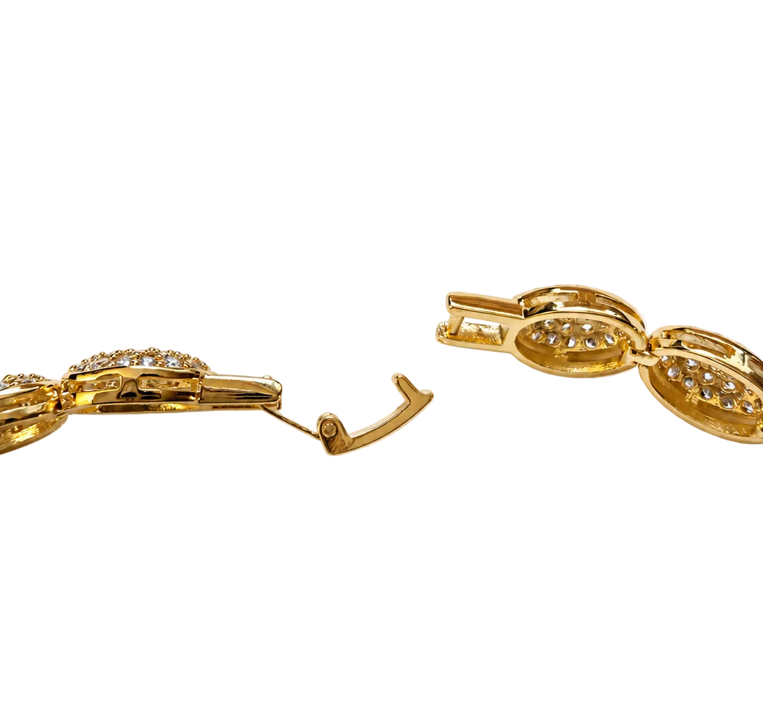 Close-up of a gold-toned bracelet with oval links and small clear stones, showing the clasp mechanism on a plain white background.