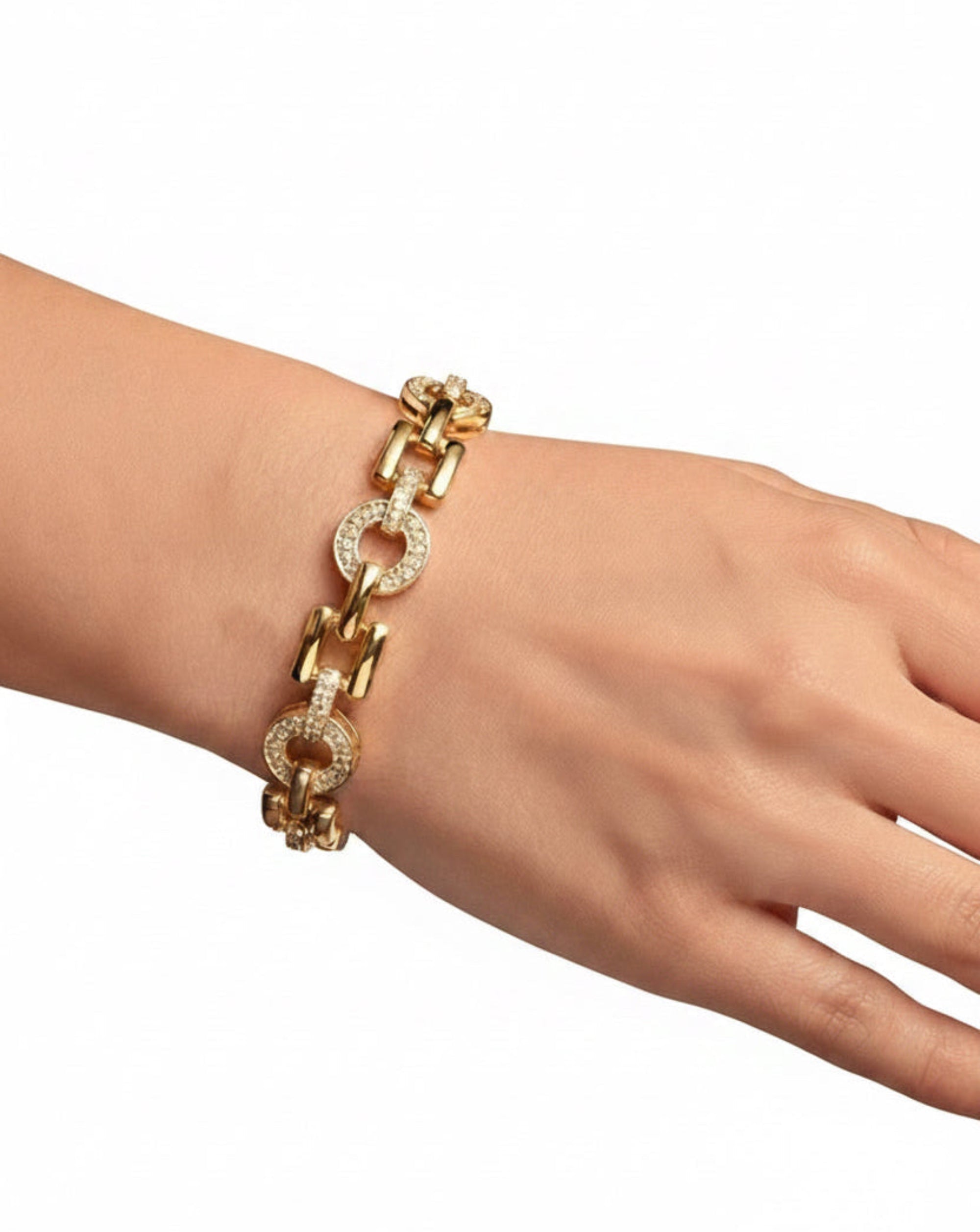 A gold chain bracelet with circular links, some adorned with clear pavé stones, worn on a person's wrist in a luxury jewelry store.