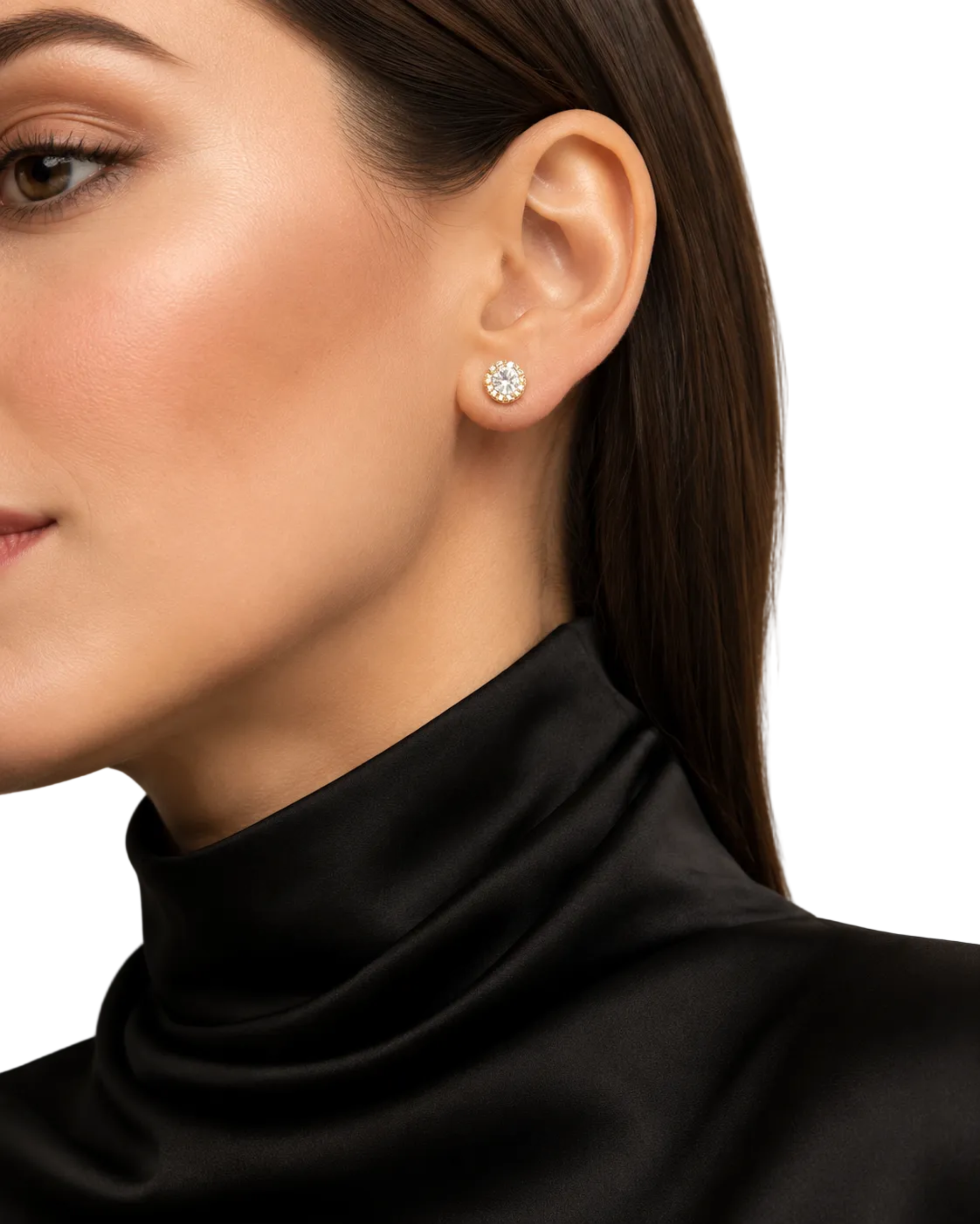 A close-up of a woman's ear wearing a small round stud earring with a clear gemstone, paired with a black satin turtleneck top against a soft beige background.