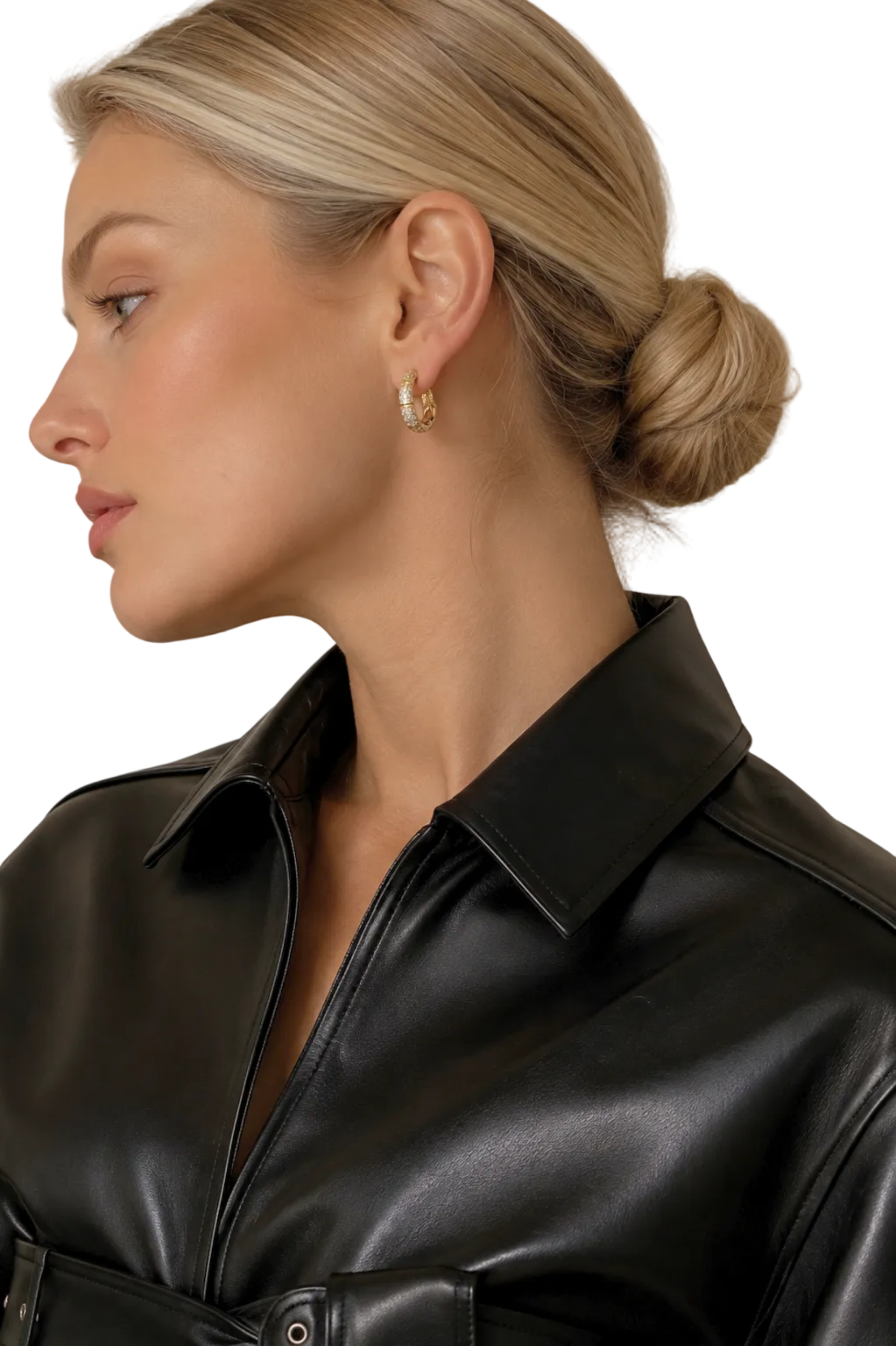 A close-up side profile of a blonde woman wearing a small gold hoop earring with clear stones, paired with a black leather shirt against a neutral beige background.