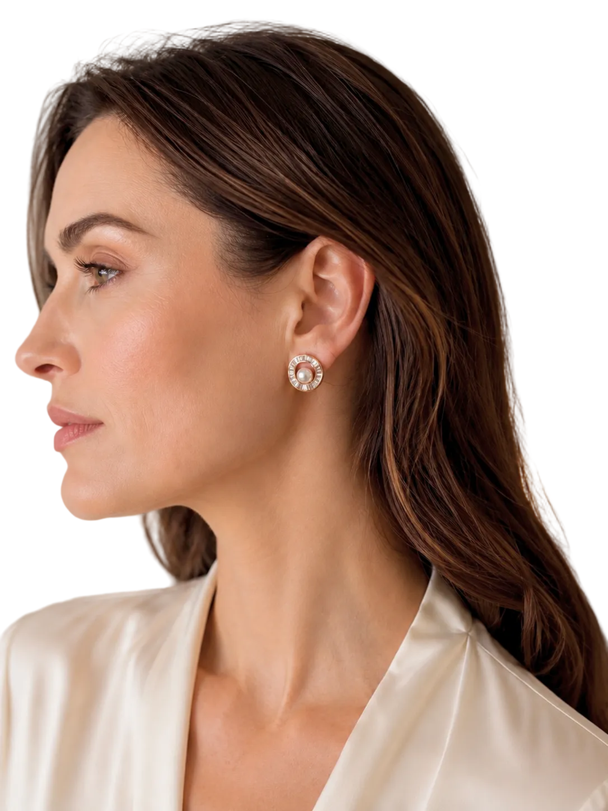 A woman in profile wearing a small circular stud earring with a white pearl center and a halo of clear stones, paired with a cream satin blouse.
