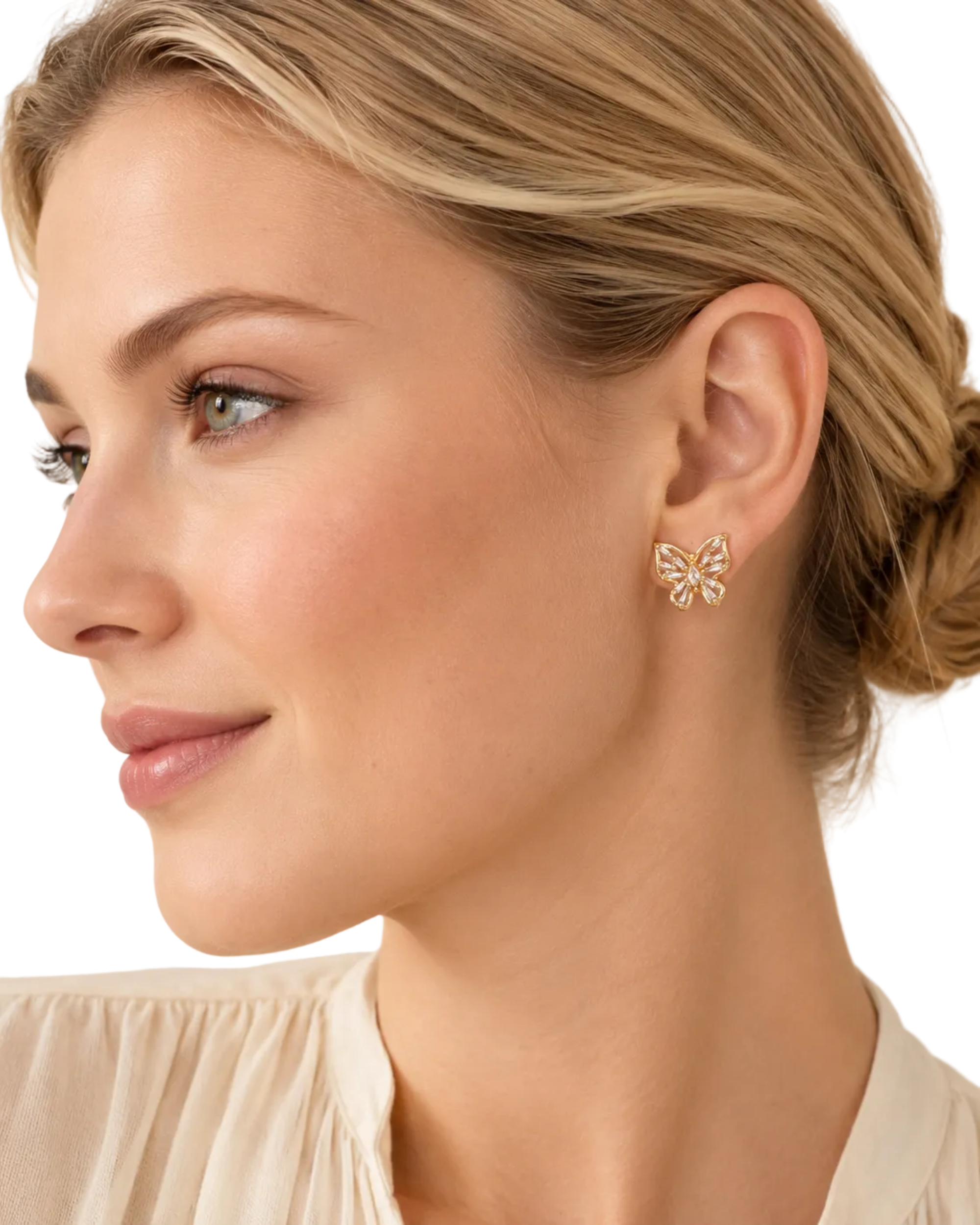 A close-up side profile of a woman with blonde hair in a low bun, wearing a small gold butterfly-shaped stud earring. She is wearing a light beige top against a soft beige background.