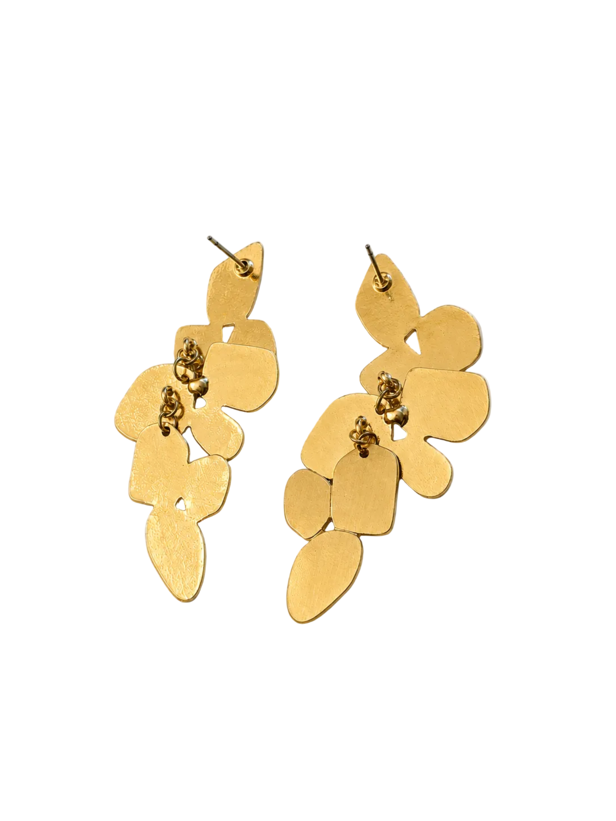 A pair of gold-toned dangle earrings with an organic, layered petal-like silhouette, displayed on a light beige background.