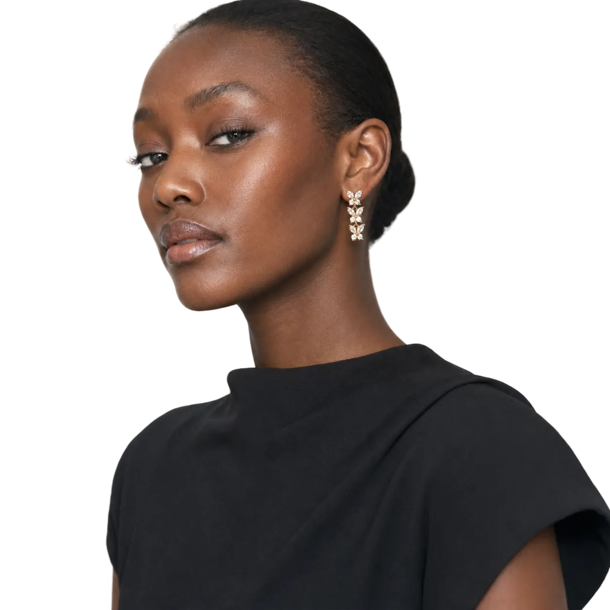 A close-up portrait of a model wearing a dangling earring with three stacked gold-toned oval motifs set with clear stones, against a plain light background.