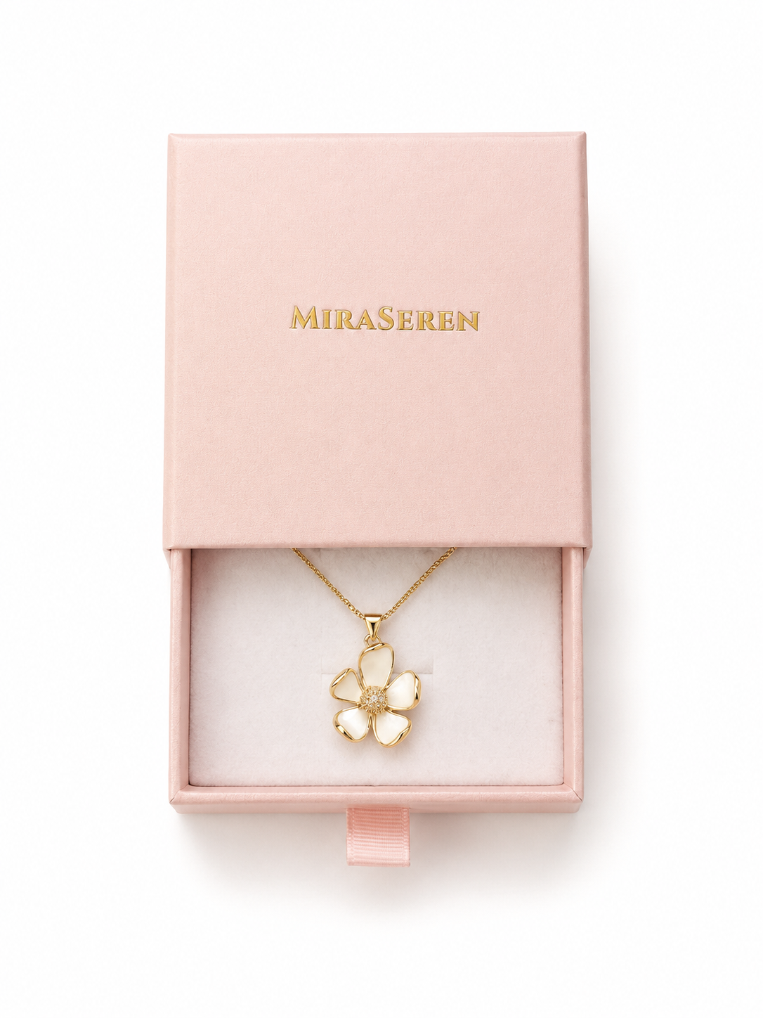 A gold flower-shaped pendant necklace with white enamel details, presented inside a light pink Miraseren jewelry box on a white background.