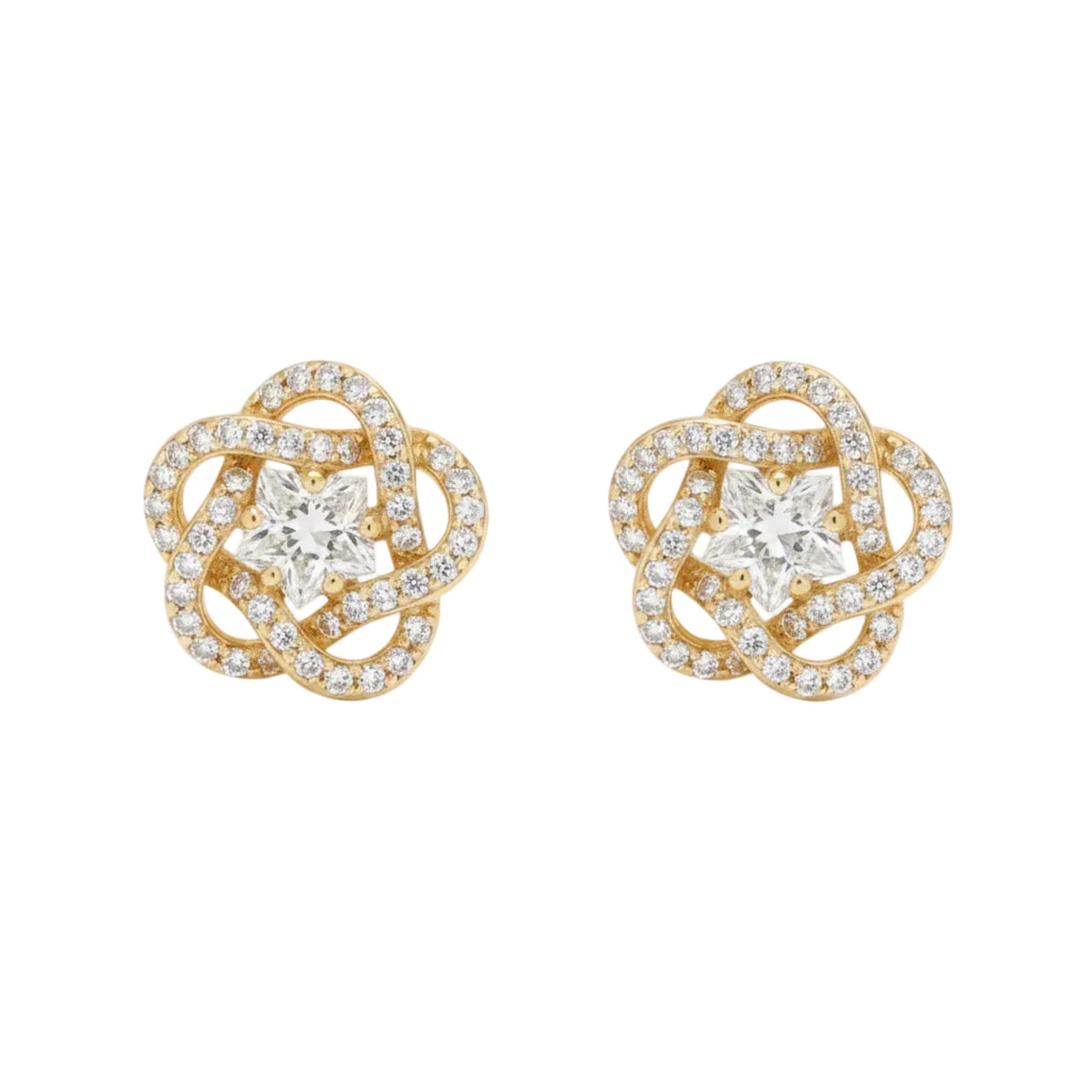 A pair of gold flower-shaped stud earrings with a central clear gemstone and surrounding pavé-set clear stones, shown on a light gray background.