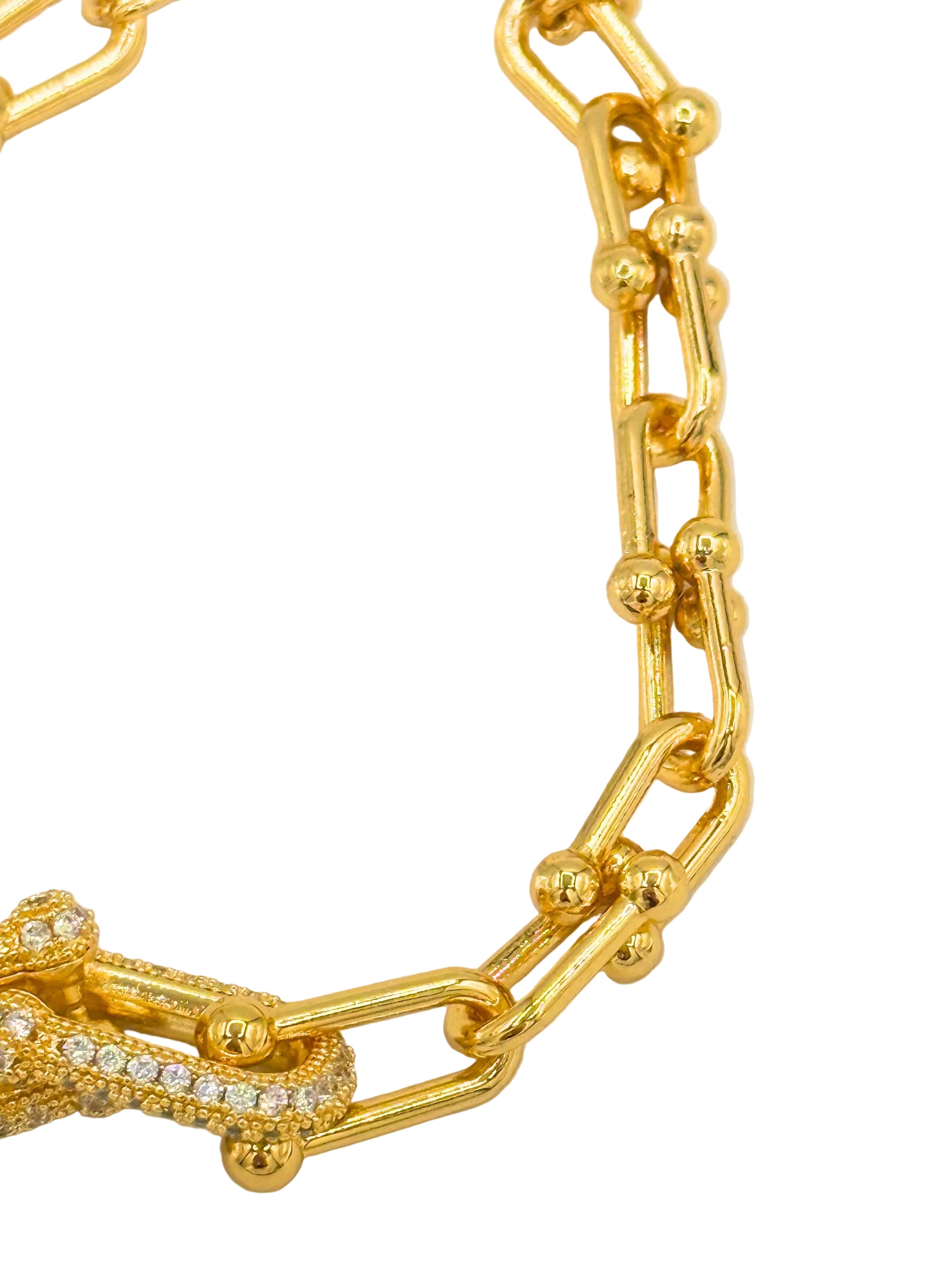 A gold chain necklace with a distinctive lobster clasp paved with small clear stones, shown against a plain white background.