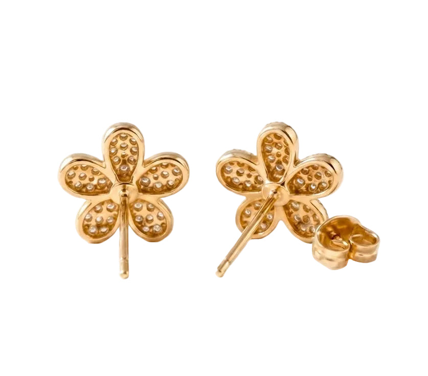 A pair of gold four-petal flower stud earrings with textured pavé detailing, shown from both front and side angles on a plain white background.